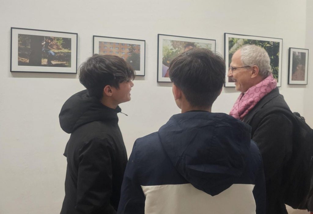 UNHCR Deputy Representative, Bülent Peker, with two young refugee photographers at the exhibition opening.